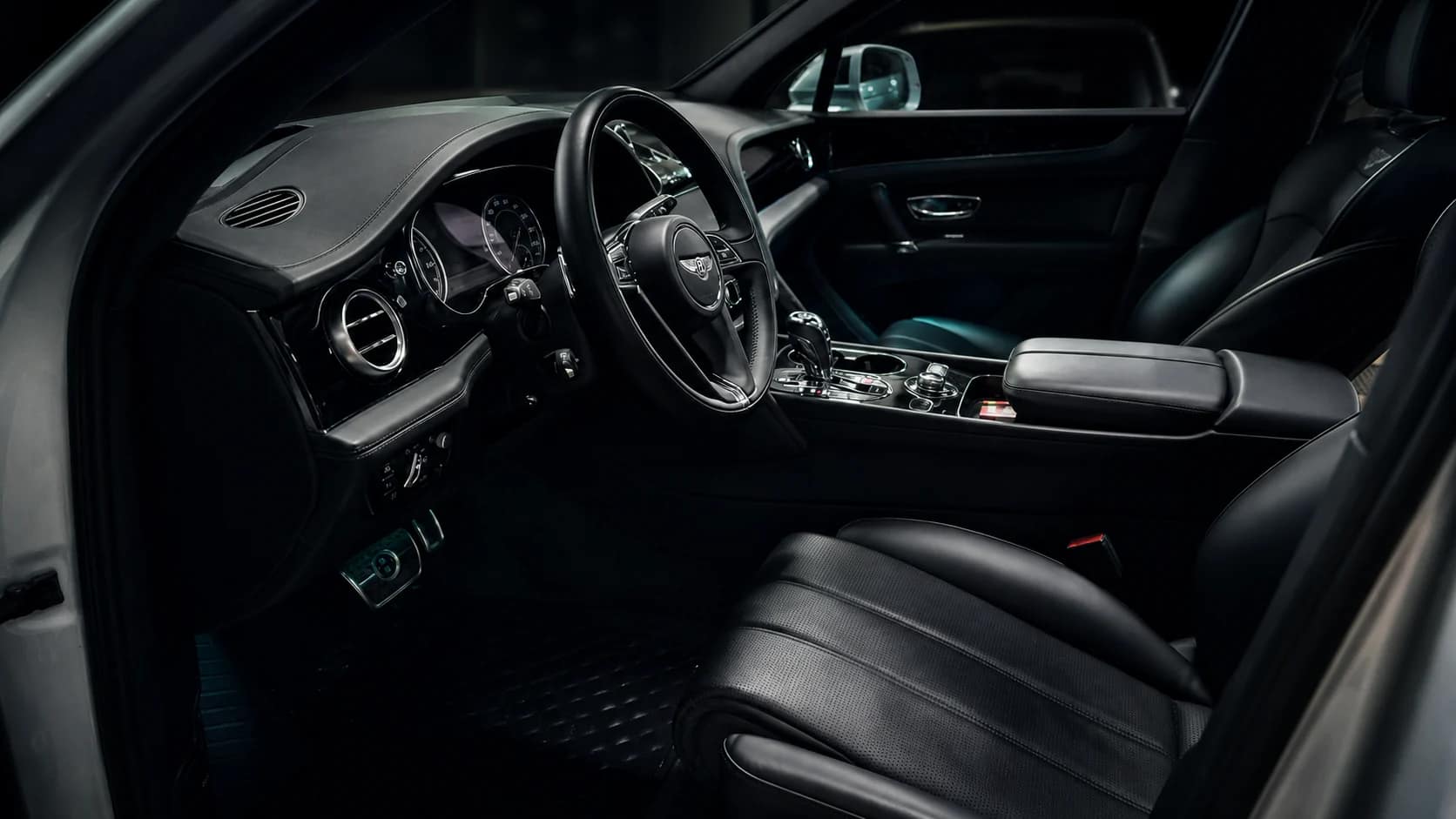 Interiør i en Bentley med sort skinn, sett fra førersiden