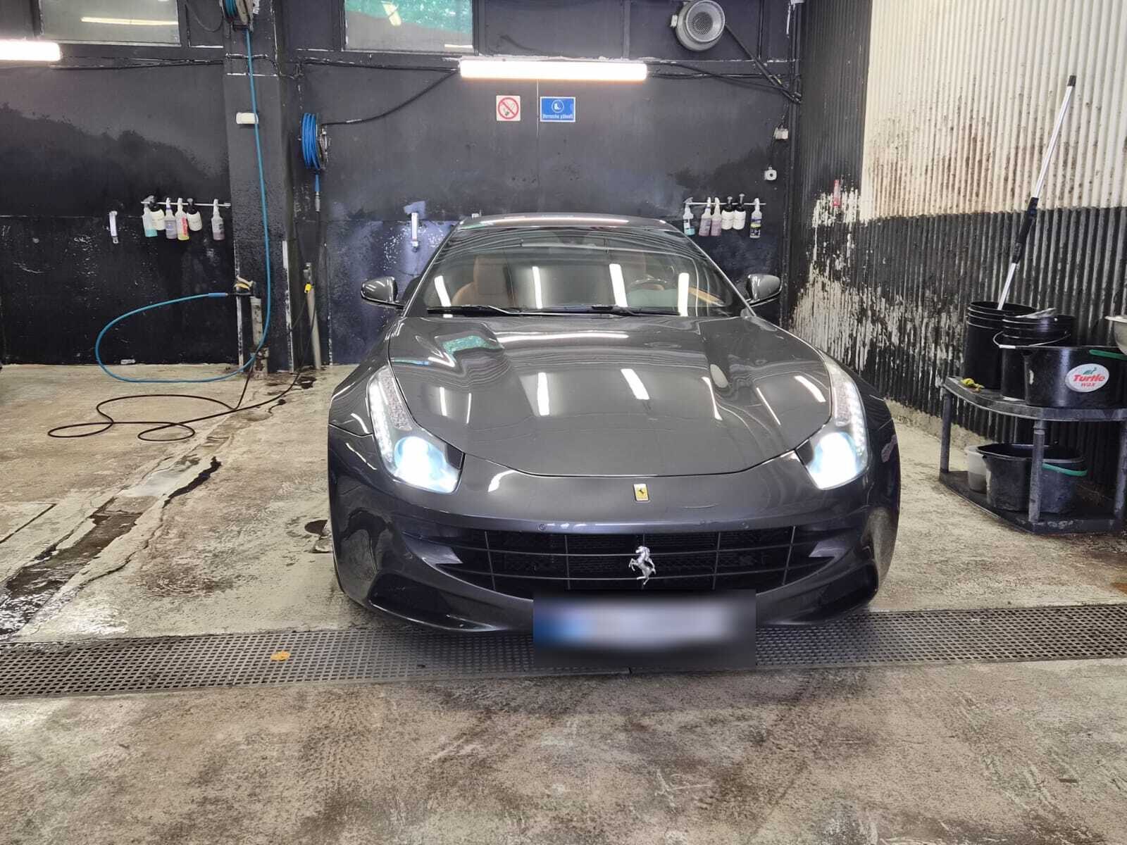 Mørk Ferrari FF sett forfra med tente frontlys